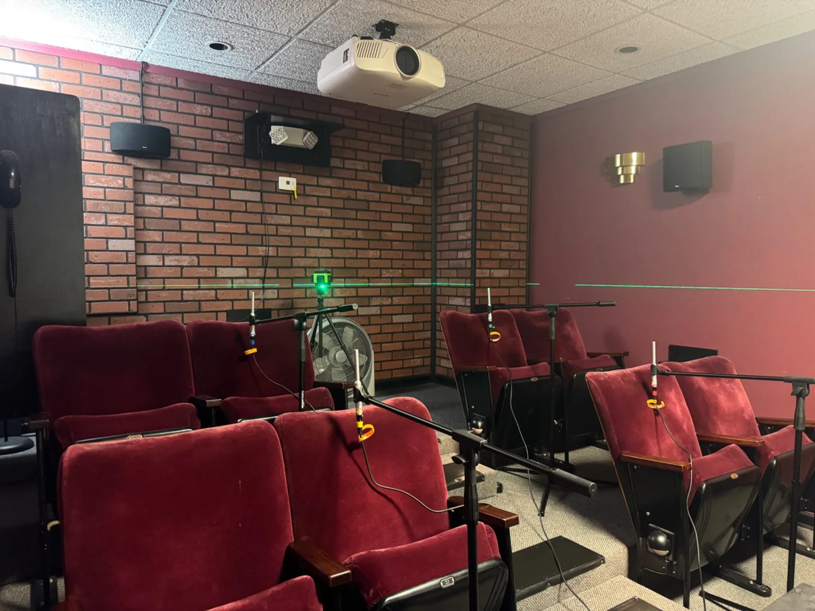 Measurement microphones at each seat in a client theater
